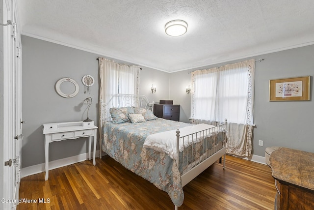 bedroom with dark wood-type flooring, ornamental molding, and a textured ceiling