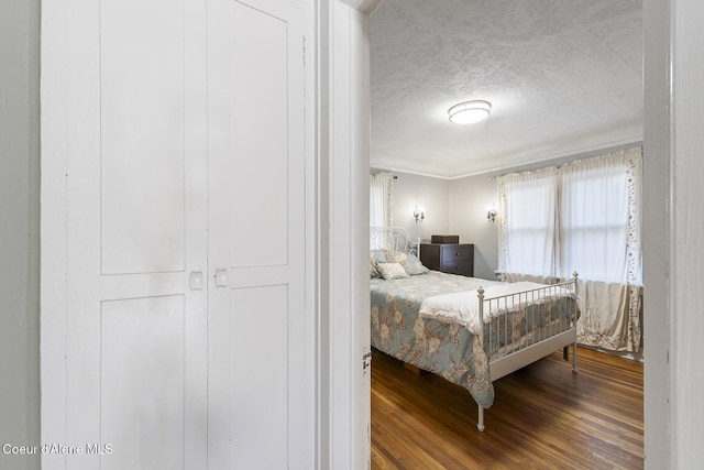 bedroom with wood-type flooring and a textured ceiling