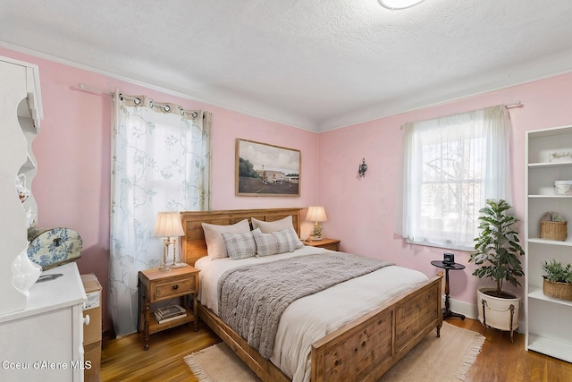 bedroom with a textured ceiling and dark hardwood / wood-style flooring