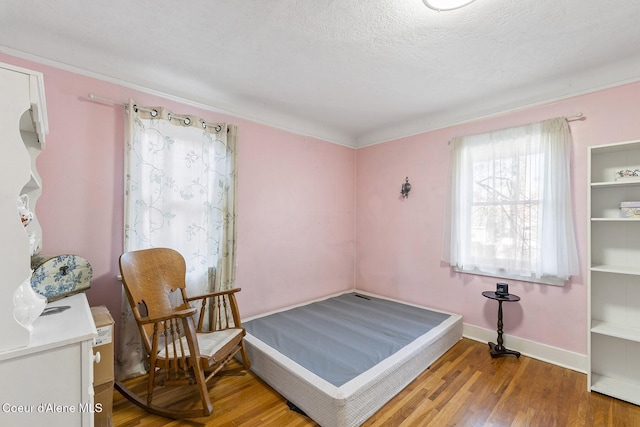 bedroom with hardwood / wood-style flooring and a textured ceiling