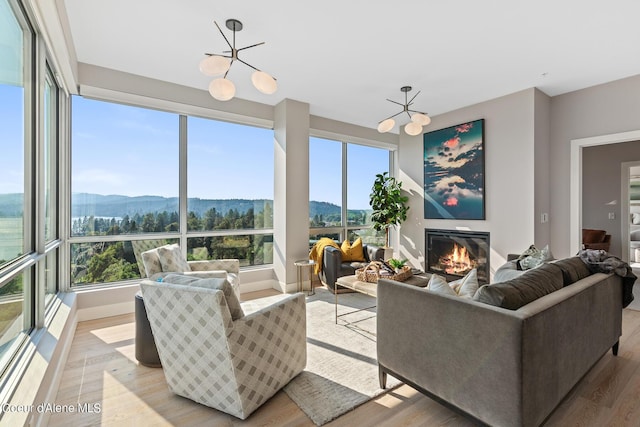 living room featuring a mountain view, light hardwood / wood-style floors, and a chandelier