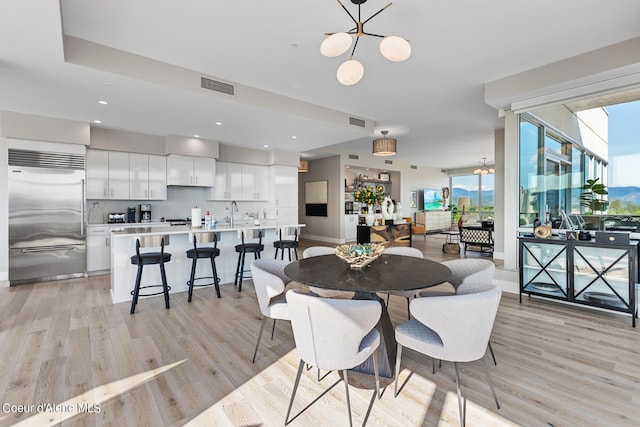 dining area with a notable chandelier and light hardwood / wood-style flooring