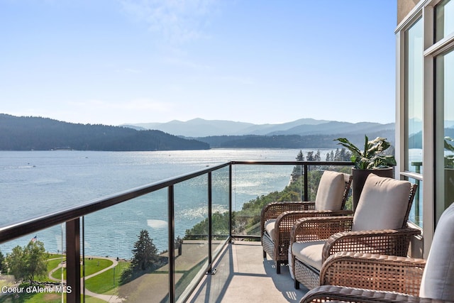 balcony featuring a water and mountain view