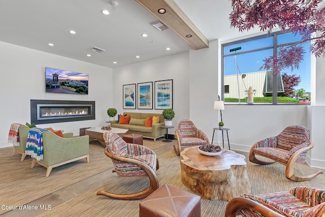 living room featuring beam ceiling and light wood-type flooring