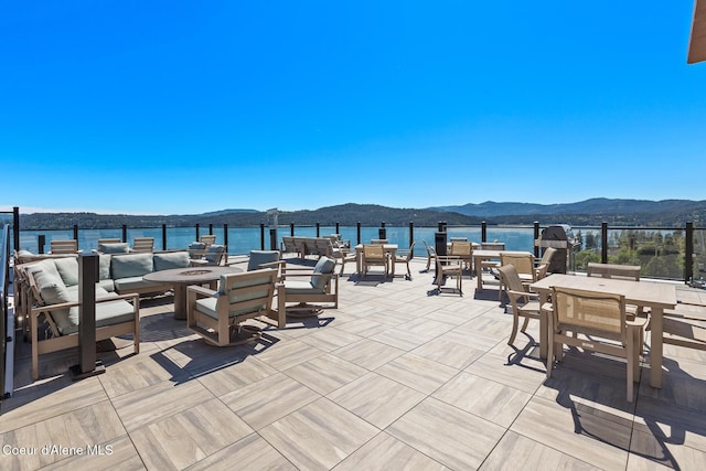 view of patio / terrace with a water and mountain view and an outdoor fire pit