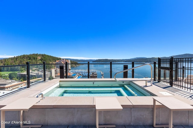 view of pool featuring an in ground hot tub and a water and mountain view