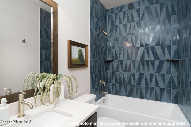 full bathroom featuring tiled shower / bath combo, vanity, and toilet