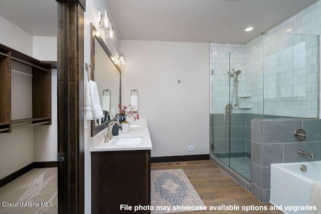 bathroom featuring vanity, hardwood / wood-style flooring, and separate shower and tub