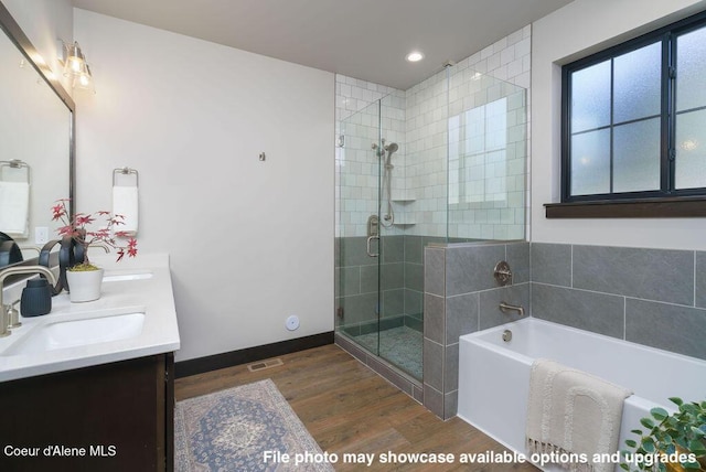 bathroom featuring vanity, hardwood / wood-style flooring, and shower with separate bathtub