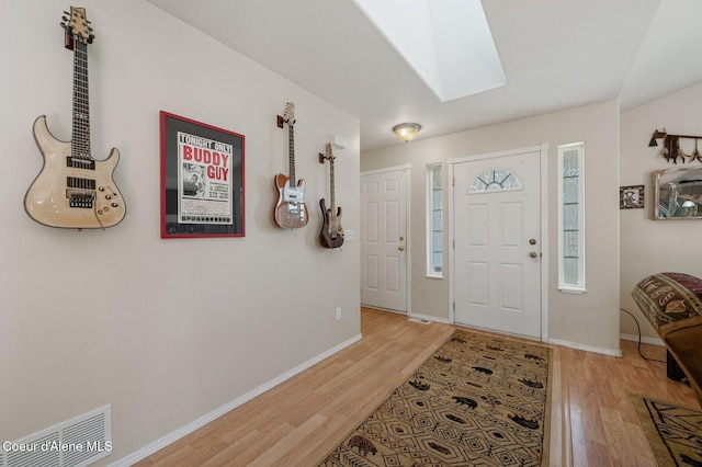 foyer featuring light wood-type flooring and a skylight