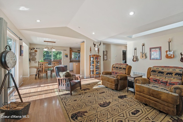 living room with vaulted ceiling and light hardwood / wood-style floors