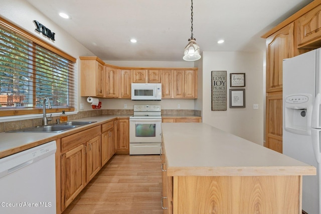 kitchen with light brown cabinetry, sink, decorative light fixtures, light hardwood / wood-style flooring, and white appliances