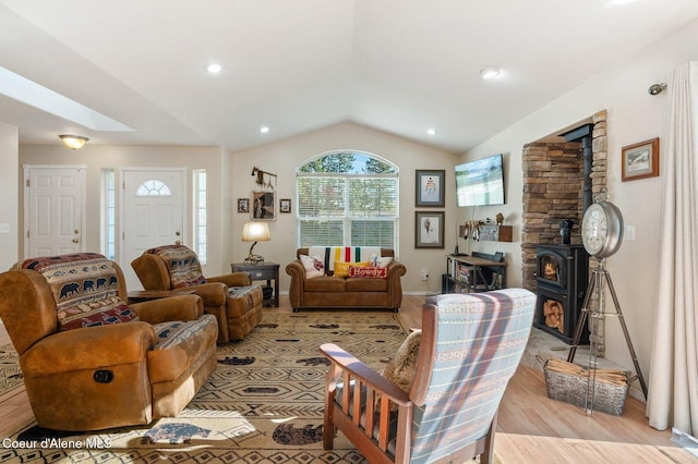 living room with lofted ceiling, light hardwood / wood-style flooring, and a wood stove