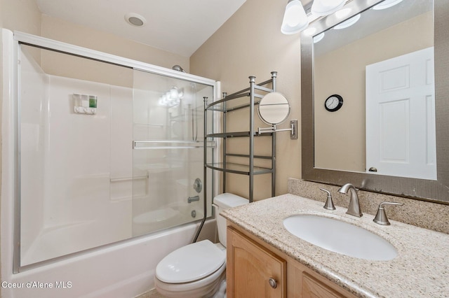 full bathroom featuring vanity, combined bath / shower with glass door, and toilet