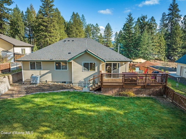 rear view of house with a deck and a lawn