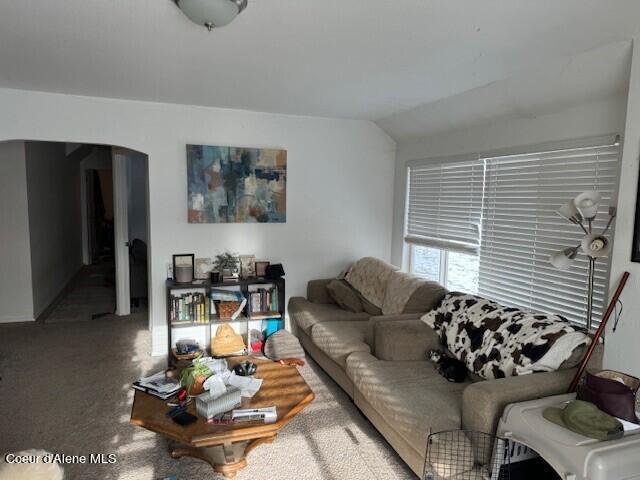 living room with lofted ceiling and carpet