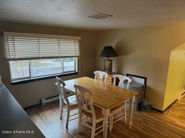 dining area with hardwood / wood-style flooring and a baseboard radiator