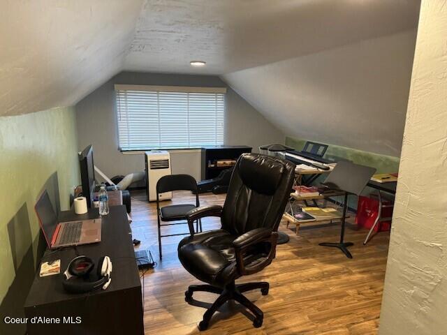 home office featuring lofted ceiling and wood-type flooring