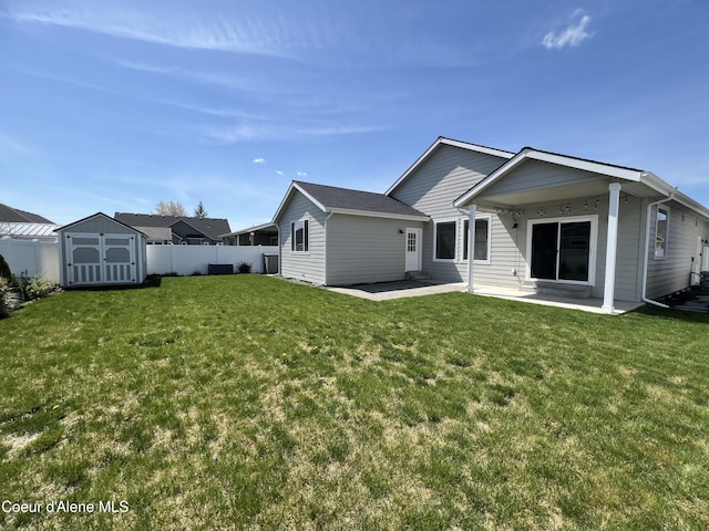 9256 Gettys Ln, Hayden, ID 83835 - back of property with a storage shed, a lawn, an outbuilding, a patio area, and a fenced backyard