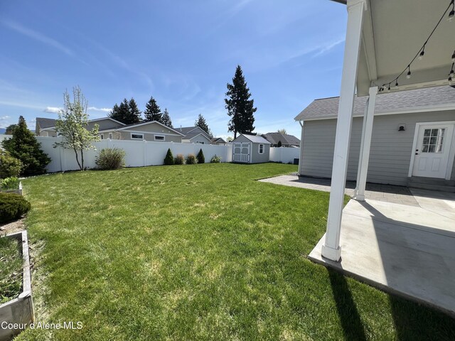 9256 Gettys Ln, Hayden, ID 83835 - view of yard with fence, a residential view, a storage shed, an outbuilding, and a patio
