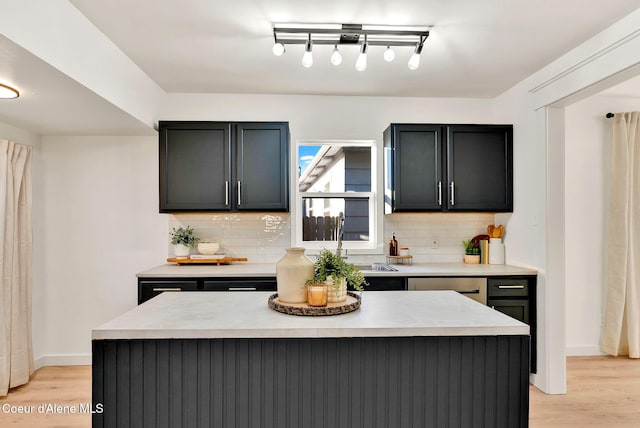 kitchen featuring decorative backsplash, a kitchen island, and light hardwood / wood-style flooring