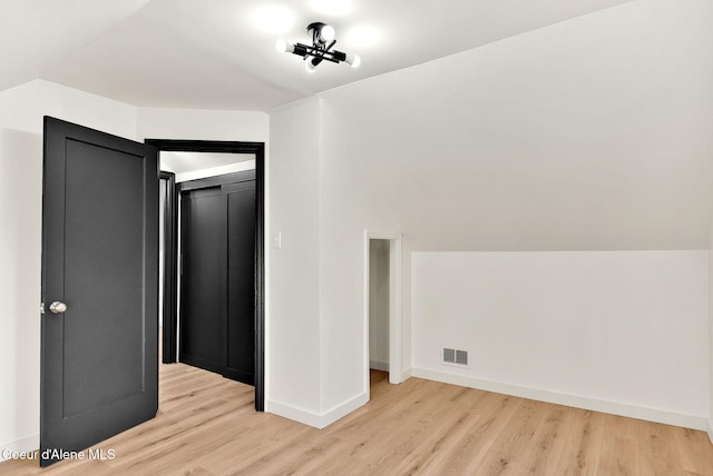 interior space with vaulted ceiling, light hardwood / wood-style floors, and a closet