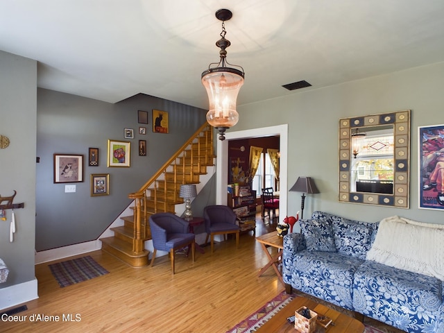 living room with hardwood / wood-style floors and a chandelier