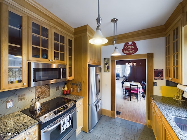 kitchen featuring a chandelier, hanging light fixtures, dark stone countertops, appliances with stainless steel finishes, and decorative backsplash