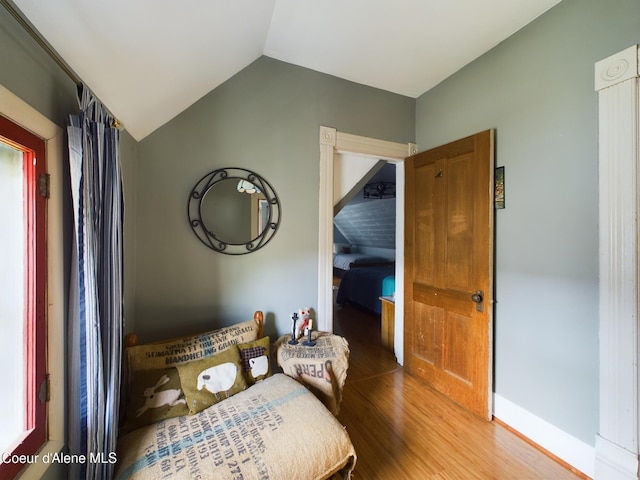 bedroom with lofted ceiling and hardwood / wood-style flooring