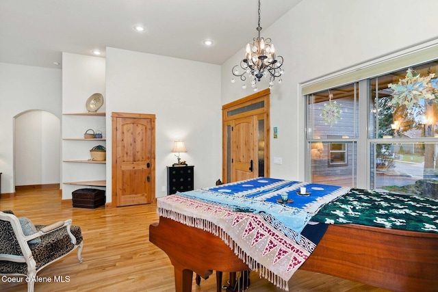 bedroom with a notable chandelier and light wood-type flooring