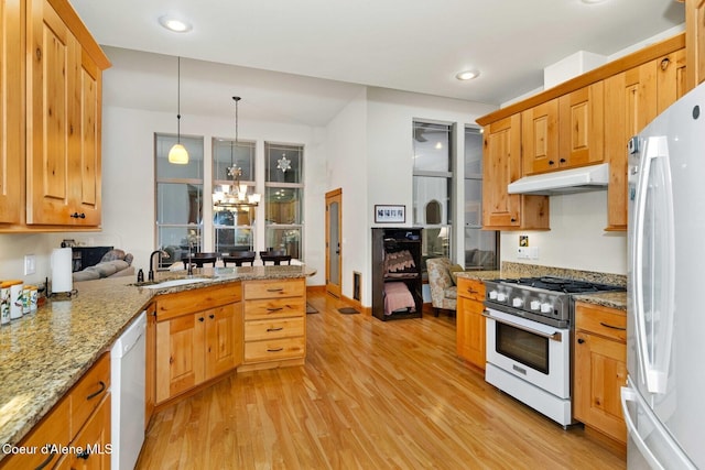 kitchen featuring sink, hanging light fixtures, light hardwood / wood-style flooring, a notable chandelier, and white appliances