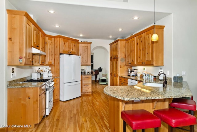 kitchen featuring sink, decorative light fixtures, kitchen peninsula, white appliances, and light stone countertops