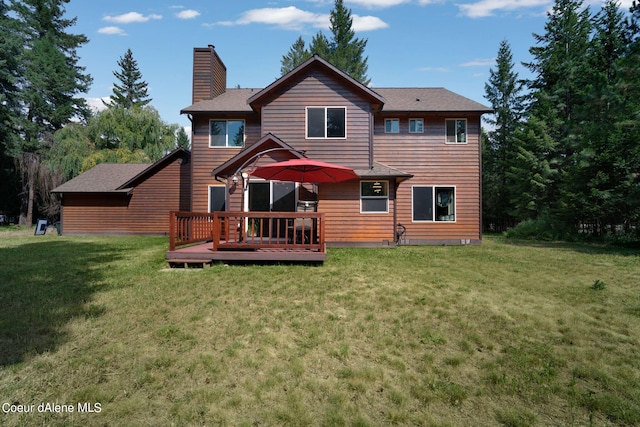 rear view of property with a deck and a lawn