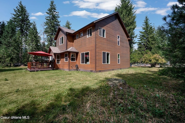 rear view of house with a yard and a deck