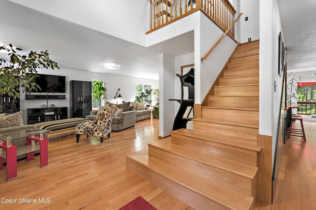 staircase with hardwood / wood-style flooring and a towering ceiling