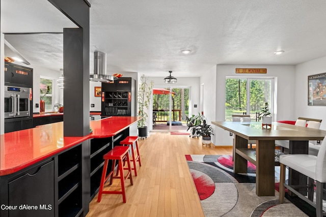 dining space featuring a textured ceiling and light hardwood / wood-style floors