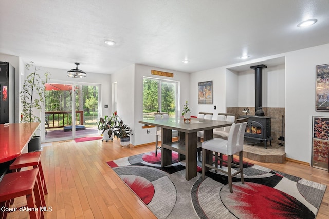 dining space featuring a wood stove and light wood-type flooring