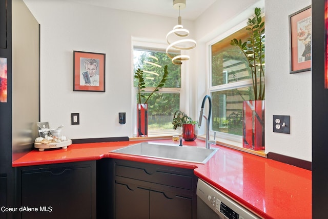 kitchen with dishwashing machine, sink, and hanging light fixtures