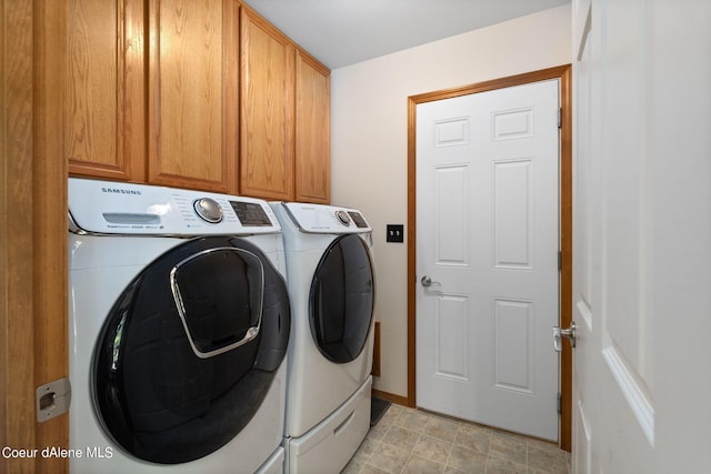 clothes washing area featuring cabinets and washer and dryer