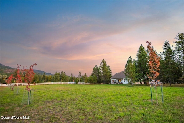 yard at dusk with a mountain view and a rural view