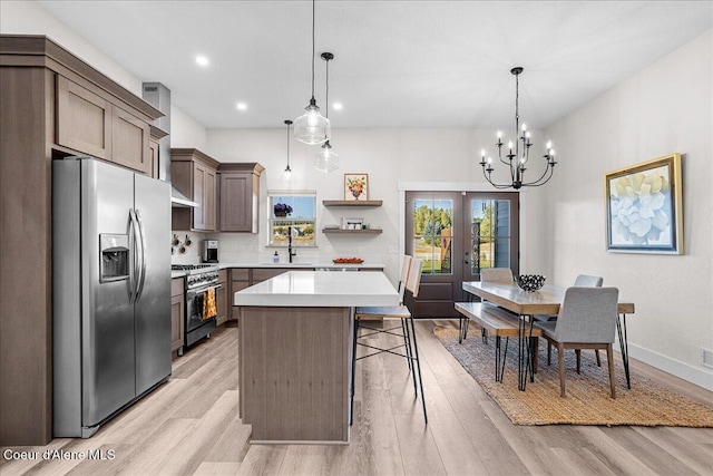 kitchen featuring stainless steel appliances, sink, hanging light fixtures, and a kitchen island