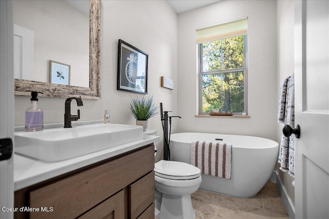 bathroom featuring vanity, tile patterned floors, toilet, and a bathing tub