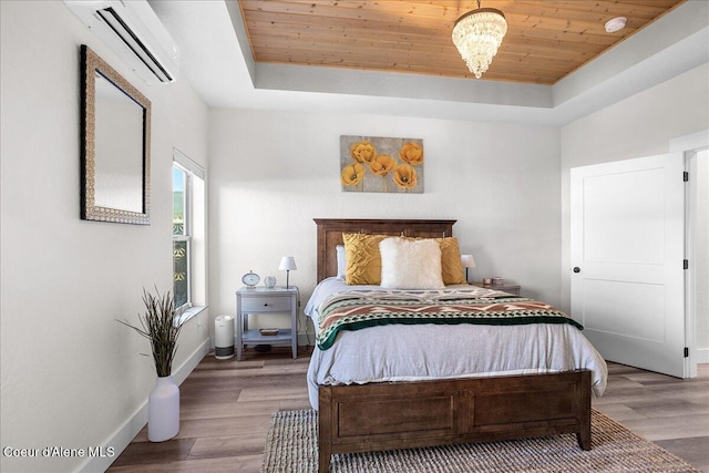 bedroom featuring a raised ceiling, a wall mounted AC, hardwood / wood-style floors, and wooden ceiling