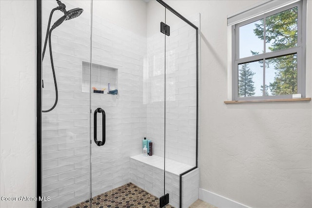 bathroom featuring a shower with shower door