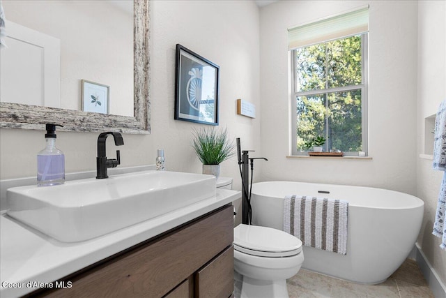 bathroom with vanity, a bath, tile patterned floors, and toilet