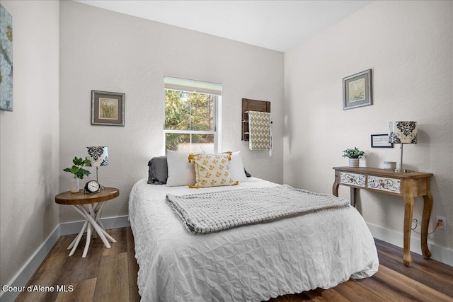 bedroom with dark hardwood / wood-style flooring