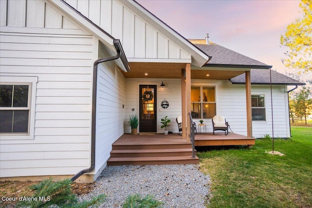 exterior entry at dusk featuring a yard