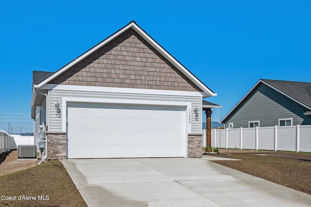 view of front of house featuring central AC unit, a garage, and a front yard