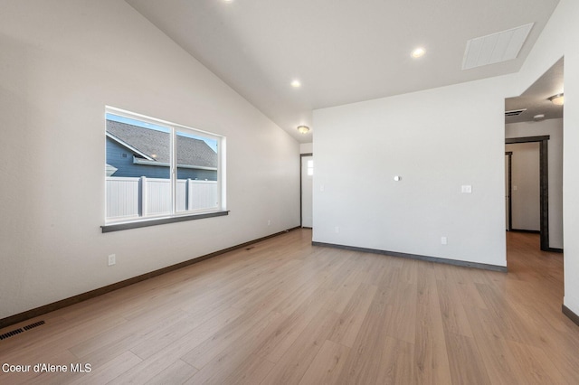 empty room featuring high vaulted ceiling and light hardwood / wood-style floors