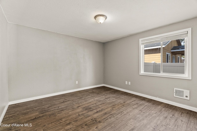 spare room featuring wood-type flooring and a textured ceiling